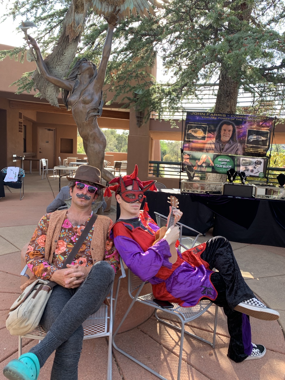 IMP in colorful jester costume beside another performer